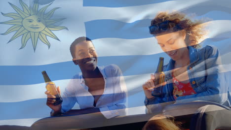 Composite-Video-Der-Uruguayischen-Flagge-Vor-Zwei-Unterschiedlichen-Mädchen,-Die-Bier-Trinken-Und-Im-Auto-Reden