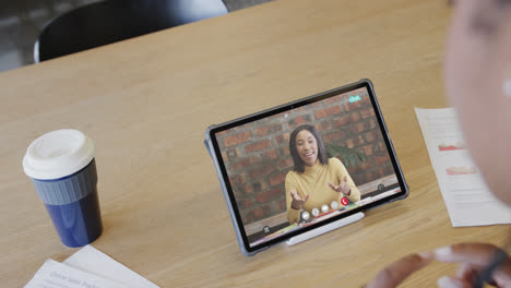 Caucasian-businesswoman-on-tablet-video-call-with-caucasian-female-colleague-on-screen