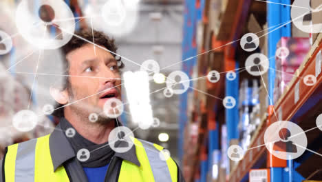 Animation-of-network-of-connections-with-icons-over-caucasian-male-worker-working-in-warehouse
