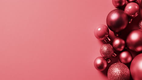 Video-of-red-baubles-christmas-decorations-with-copy-space-on-red-background