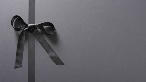 Video-of-black-gift-ribbon-and-bow-with-copy-space-on-black-background