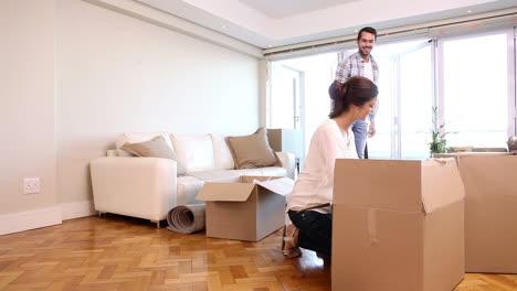 Attractive-couple-unpacking-boxes-in-their-living-room