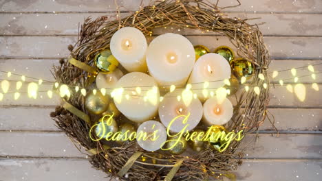 Animation-of-season's-greetings-text-and-string-lights-over-candles-and-christmas-wreath