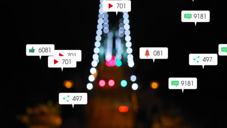 Animation-of-social-media-icons-falling-against-blurred-aerial-view-of-night-city-traffic