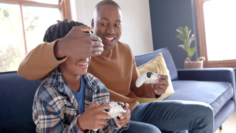 Feliz-Padre-E-Hijo-Afroamericanos-Jugando-Videojuegos-Y-Jugando-En-Casa,-Cámara-Lenta