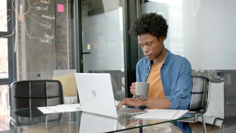 Afroamerikanischer-Gelegenheitsgeschäftsmann-Mit-Laptop-Und-Kaffeetrinken-Am-Schreibtisch,-Zeitlupe