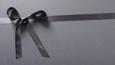 Video-of-black-gift-ribbon-and-bow-with-copy-space-on-black-background