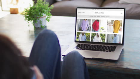 Woman-at-table-using-laptop,-online-shopping-for-clothes,-slow-motion
