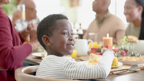 Portrait-of-african-american-son-with-family-at-thanksgiving-dinner-table,-slow-motion
