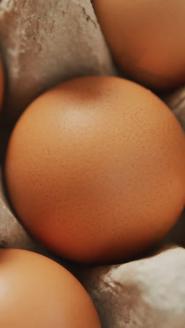 Video-of-close-up-of-brown-eggs-in-egg-carton-background