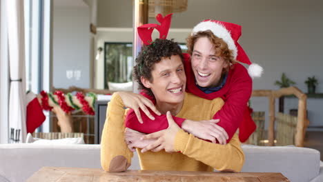 Happy-diverse-gay-male-couple-using-having-video-call-at-home-at-christmas,-slow-motion