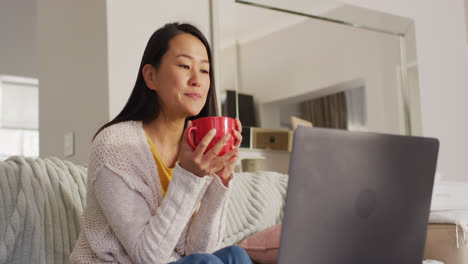 Video-De-Una-Mujer-Asiática-Feliz-Con-Café-Usando-Una-Computadora-Portátil