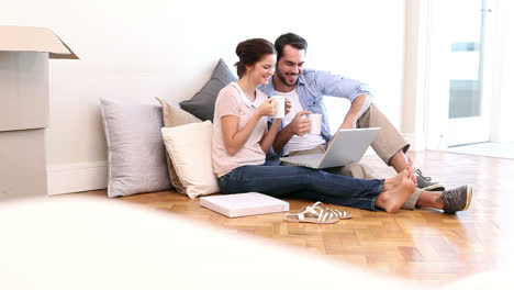 Attractive-couple-using-laptop-on-the-floor