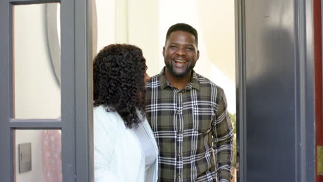 Glückliches-Afroamerikanisches-Paar-Empfängt-Gäste-Im-Sonnigen-Zuhause