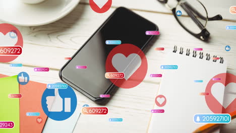 Animation-of-social-media-like-and-love-icons-over-smartphone-on-desk-background