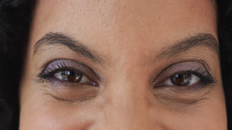 Close-up-portrait-of-happy-eyes-of-biracial-woman-at-home,-slow-motion