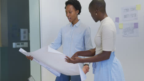 Dos-Felices-Arquitectas-Afroamericanas-En-Discusión-Estudiando-Planos-En-La-Oficina