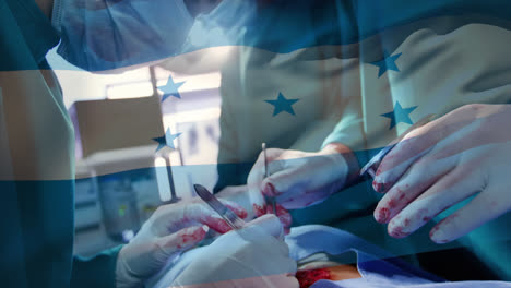 Animation-of-waving-honduras-flag-against-team-of-diverse-surgeons-performing-operation-at-hospital