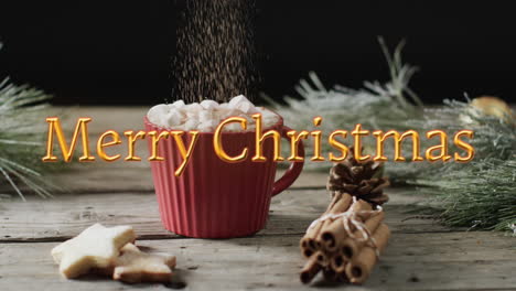 Merry-christmas-text-in-orange-over-hot-chocolate-with-marshmallows,-cookies-and-cinnamon-sticks
