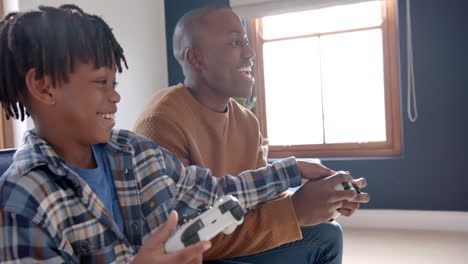 Glücklicher-Afroamerikanischer-Vater-Und-Sohn,-Die-Videospiele-Spielen-Und-Zu-Hause-Herumalbern,-Zeitlupe