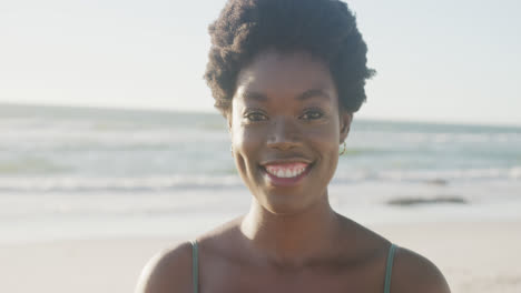 Portrait-of-happy-african-american-woman-smiling-at-beach,-in-slow-motion