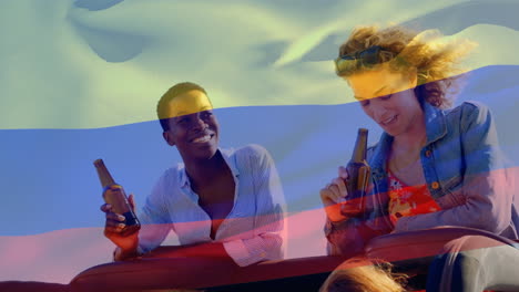 Composite-Video-Einer-Wehenden-Kolumbianischen-Flagge-über-Zwei-Unterschiedlichen-Mädchen,-Die-Bier-Trinken-Und-Im-Auto-Reden