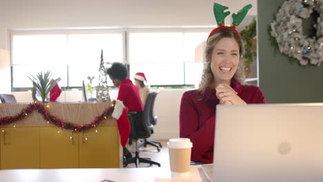Happy-caucasian-casual-businesswoman-with-reindeer-hat-making-video-call-at-christmas,-slow-motion