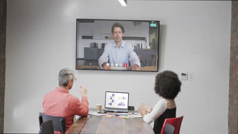 Diverse-business-people-on-video-call-with-caucasian-male-colleague-on-screen