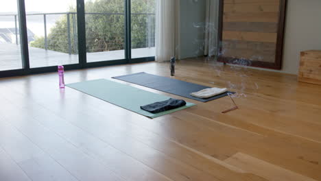 Yoga-mats,-water-bottles-and-incense-on-floor,-slow-motion