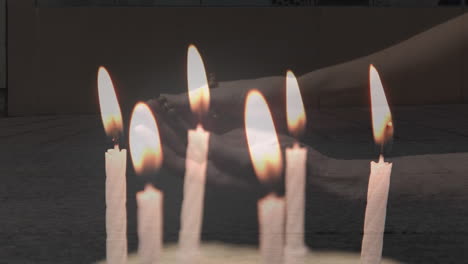 Composite-Video-Von-Kerzen,-Die-über-Frauenhänden-Mit-Rosenkranzgebet-Vor-Passanten-Ausblasen