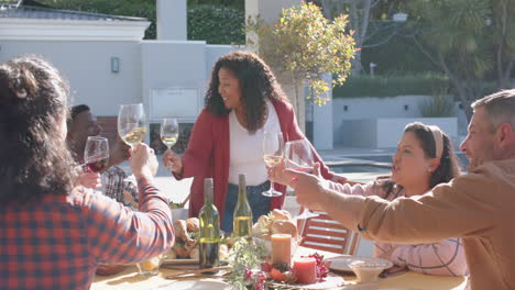 Happy-african-american-woman-toasting-on-thanksgiving-celebration-meal-in-sunny-garden