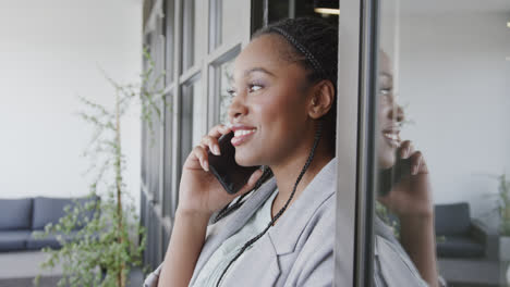Glückliche-Afroamerikanische-Geschäftsfrau,-Die-In-Der-Bürolounge-Auf-Dem-Smartphone-Spricht,-Zeitlupe