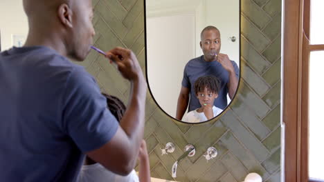 Afroamerikanischer-Vater-Und-Sohn-Putzen-Sich-Zu-Hause-Im-Badezimmer-Die-Zähne,-Zeitlupe