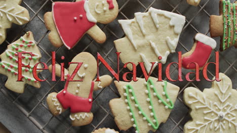 Feliz-navidad-text-in-red-over-decorated-christmas-cookies