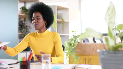 Mujer-De-Negocios-Informal-Afroamericana-Con-Afro-Usando-Documento-En-La-Oficina,-Cámara-Lenta