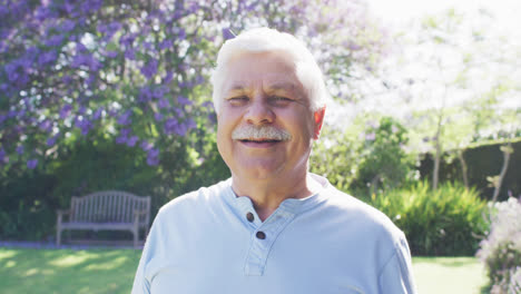 Portrait-of-happy-senior-caucasian-man-with-moustache-smiling-in-garden,-in-slow-motion