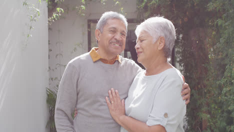 Portrait-of-happy-senior-diverse-couple-looking-at-camera-in-garden