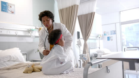 Afroamerikanische-Ärztin-Untersucht-Mädchen-Mit-Stethoskop-Im-Krankenhauszimmer,-Zeitlupe