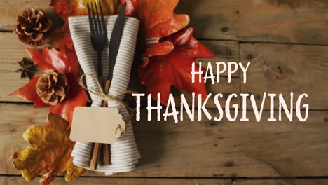 Animation-of-happy-thanksgiving-over-place-setting-on-wooden-background