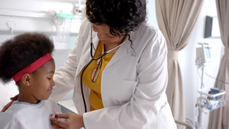 Afroamerikanische-Ärztin-Untersucht-Mädchen-Mit-Stethoskop-Im-Krankenhauszimmer,-Zeitlupe