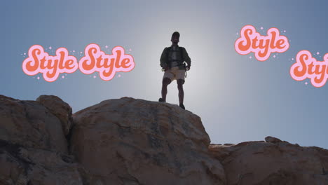 Animation-of-red-and-pink-style-text-over-hiking-african-american-man-celebrating-on-cliff-top