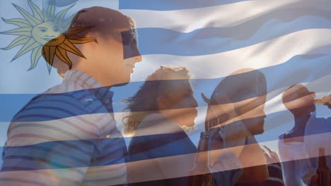 Composite-Video-Der-Uruguayischen-Flagge-Vor-Einer-Gruppe-Unterschiedlicher-Freunde,-Die-Gemeinsam-Im-Freien-Bier-Trinken