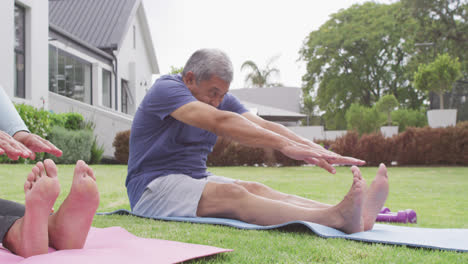 Glückliches-älteres,-Vielfältiges-Paar,-Das-Yoga-Im-Garten-Praktiziert