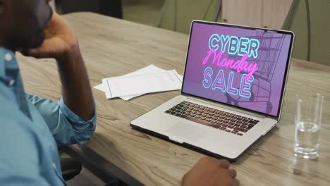 Afroamerikanischer-Mann-Am-Tisch-Mit-Laptop,-Online-Shopping-Während-Des-Cyber-Monday-Verkaufs,-Zeitlupe