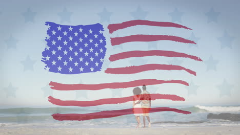 Animation-Des-Designs-Der-US-Flagge-Vor-Der-Rückansicht-Eines-Afroamerikanischen-Paares,-Das-Am-Strand-Spazieren-Geht