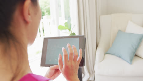 Mujer-Asiática-Usando-Tableta-Con-Interfaz-De-Hogar-Inteligente-En-El-Dormitorio,-En-Cámara-Lenta