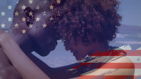 Animation-of-usa-flag-design-against-african-american-couple-embracing-each-other-at-the-beach