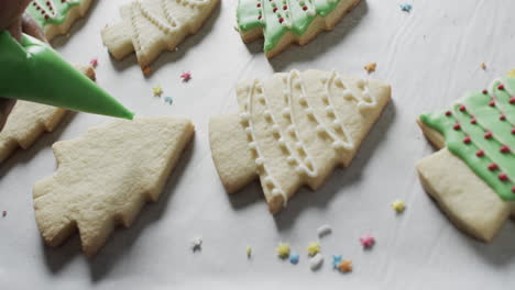 Video-of-christma-cookies-being-decorated-with-green-sugar-icing-with-copy-space-on-white-background