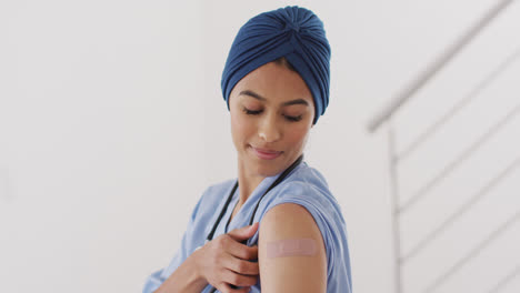 Video-De-Una-Feliz-Doctora-Birracial-Con-Hijab-Mostrando-Yeso-Después-De-La-Vacunación