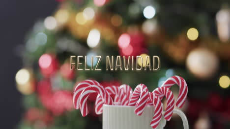 Feliz-navidad-text-and-candycanes-over-defocused-lights-on-christmas-tree